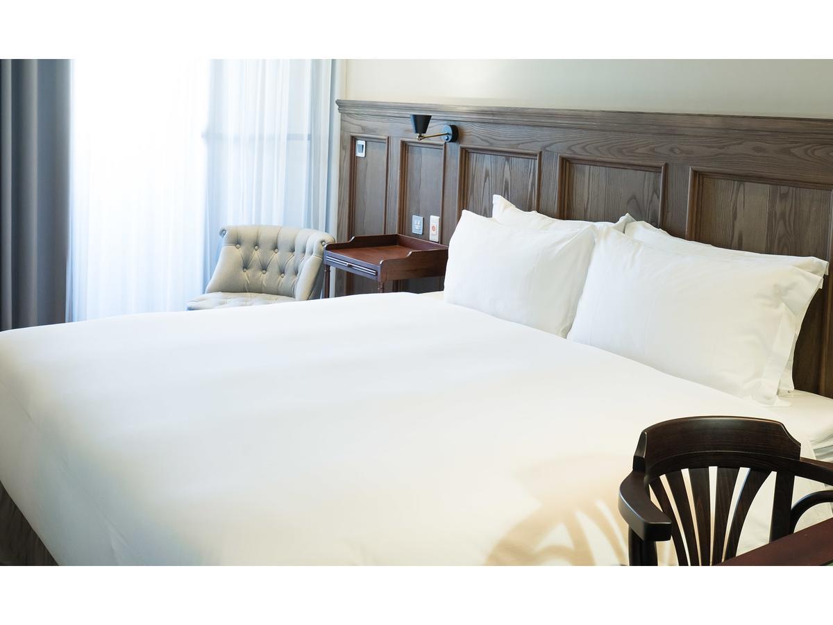 Hotel De Leau Anping Exterior foto A bed with white sheets